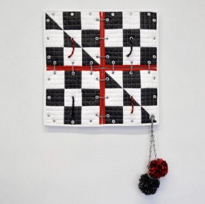 Quilt made from faux leather, vinyl, athletic mesh, chain, hardware, and yarn