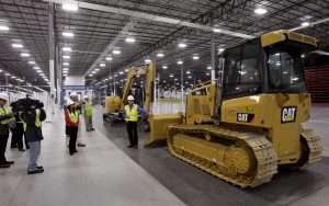 March 11, 2013 - Bogart - Todd Henry, Operations Manager (right), shows visiting media a small track-type tractor similar to what will be produced at the plant. Caterpillar's new manufacturing plant near Bogart and Athens is one of the biggest economic development projects in the state in recent years. Nearly one year after breaking ground, Caterpillar Inc. has begun moving into the 850,000 square foot facility. The current 55 employees, with 32 hired from Georgia, are the first of an expected work force of 1,400. The company expects to begin building pilot machines in June, and production models in October. The first small track-type tractors and mini hydraulic excavators are expected to begin shipping in June. The plant will become the global source for Caterpillar's small track-type tractors. BOB ANDRES / BANDRES@AJC.COM