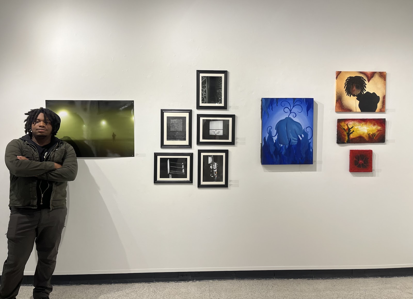 The artist standing besides his ten displayed artworks.
