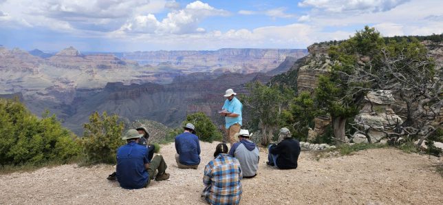 A student is presenting a lesson on the rim of the Grand Canyon with the scenic landscape in the background.