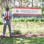Sterlin Sanders standing next the Valdosta State University sign